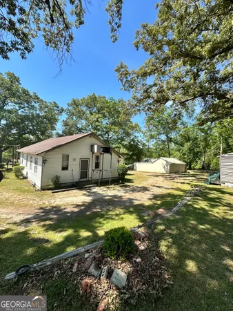 a view of a house with backyard and sitting area