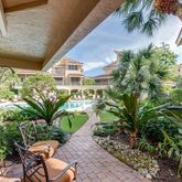 a patio with table and chairs and potted plants
