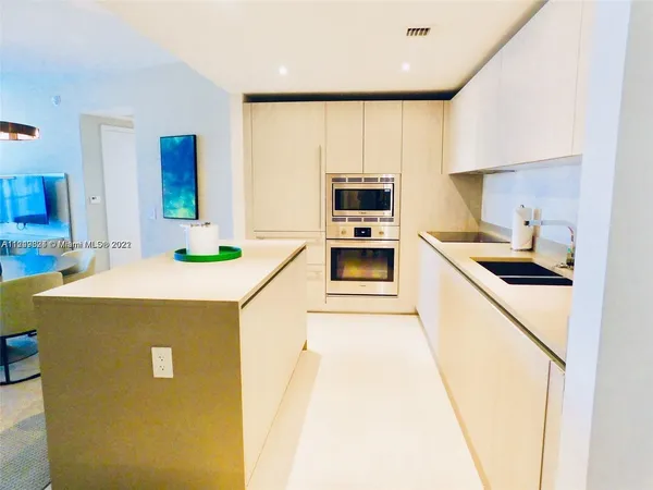 a kitchen with stainless steel appliances a table chairs and a refrigerator