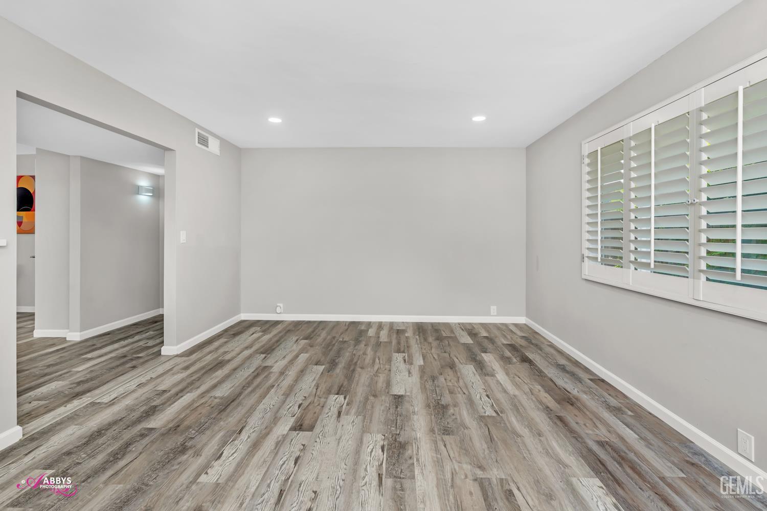 Undisclosed Address Bakersfield, CA 93309 - Photo 11 of 22 a view of an empty room with wooden floor and a window