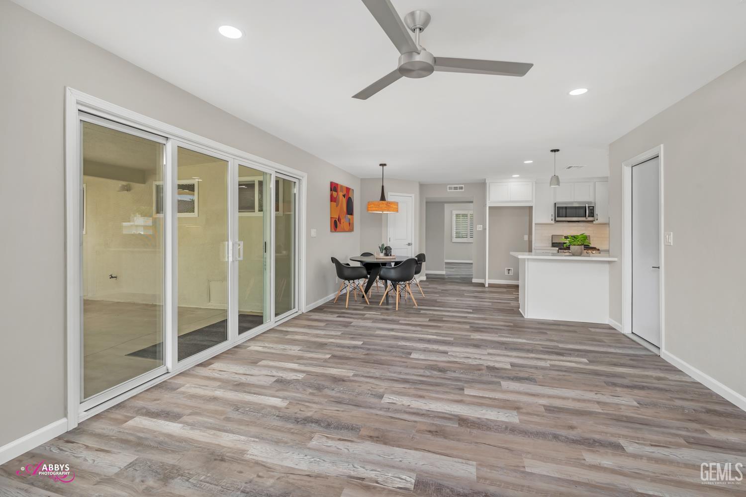 Undisclosed Address Bakersfield, CA 93309 - Photo 5 of 22 a view of a living room and kitchen with furniture wooden floor and a ceiling fan