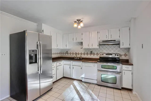 a kitchen with stainless steel appliances granite countertop a refrigerator sink and cabinets