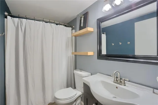 a bathroom with a sink a toilet and shower curtain