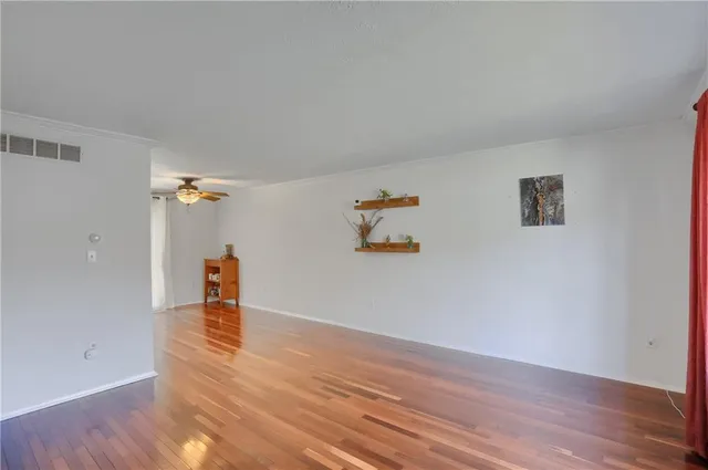 a view of empty room with wooden floor