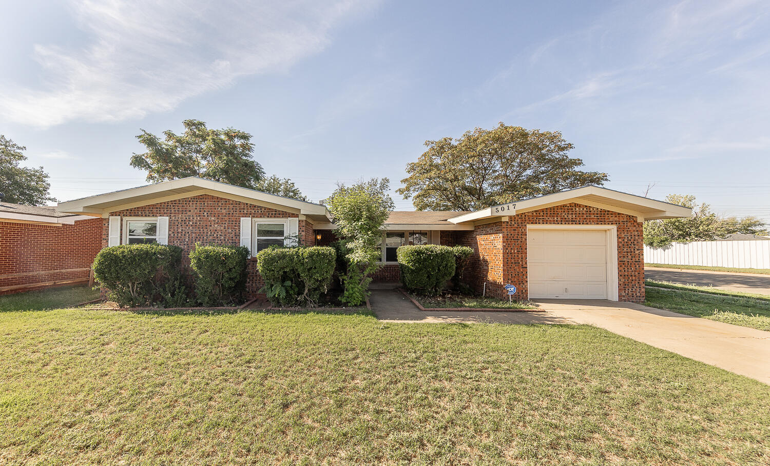 5017 46th Street Lubbock, TX 79414 - Photo 1 of 24 a front view of a house with a yard and garage