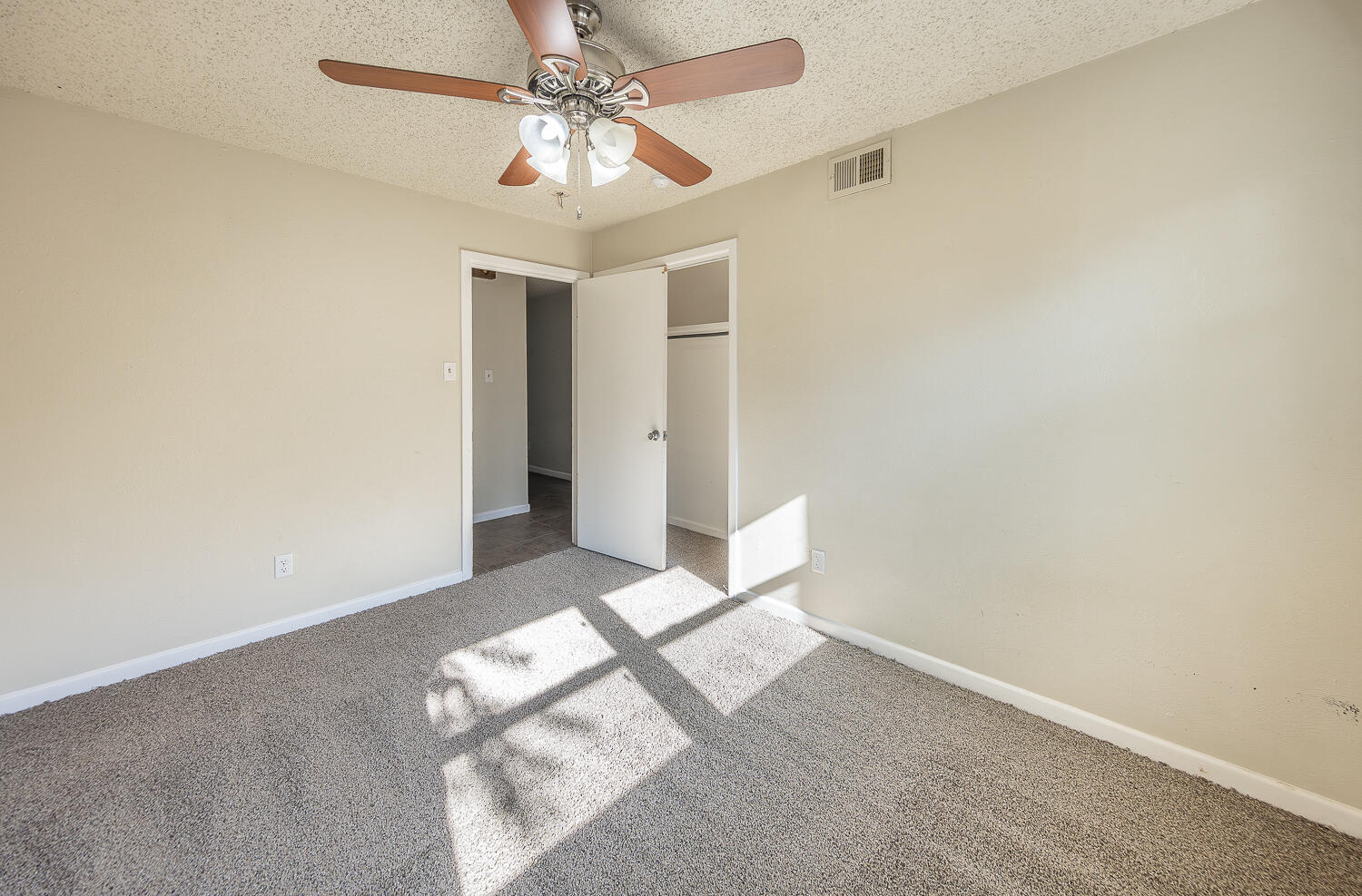 5017 46th Street Lubbock, TX 79414 - Photo 14 of 24 en empty room with windows and ceiling fan