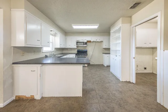 a kitchen with stainless steel appliances granite countertop a refrigerator and a stove