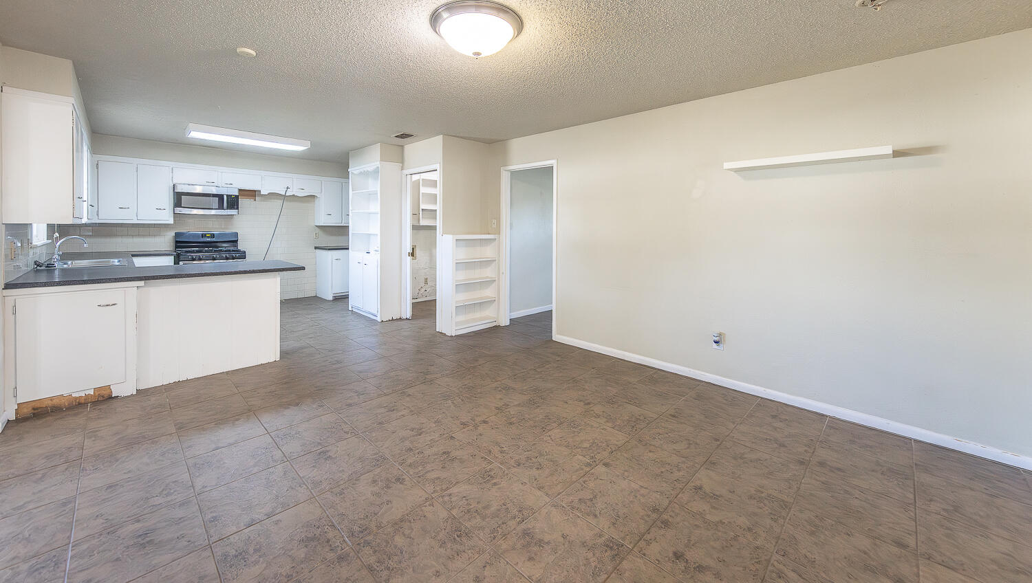 5017 46th Street Lubbock, TX 79414 - Photo 4 of 24 a view of a kitchen with refrigerator and white cabinets