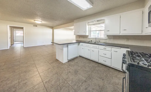 a kitchen with granite countertop white cabinets and white appliances