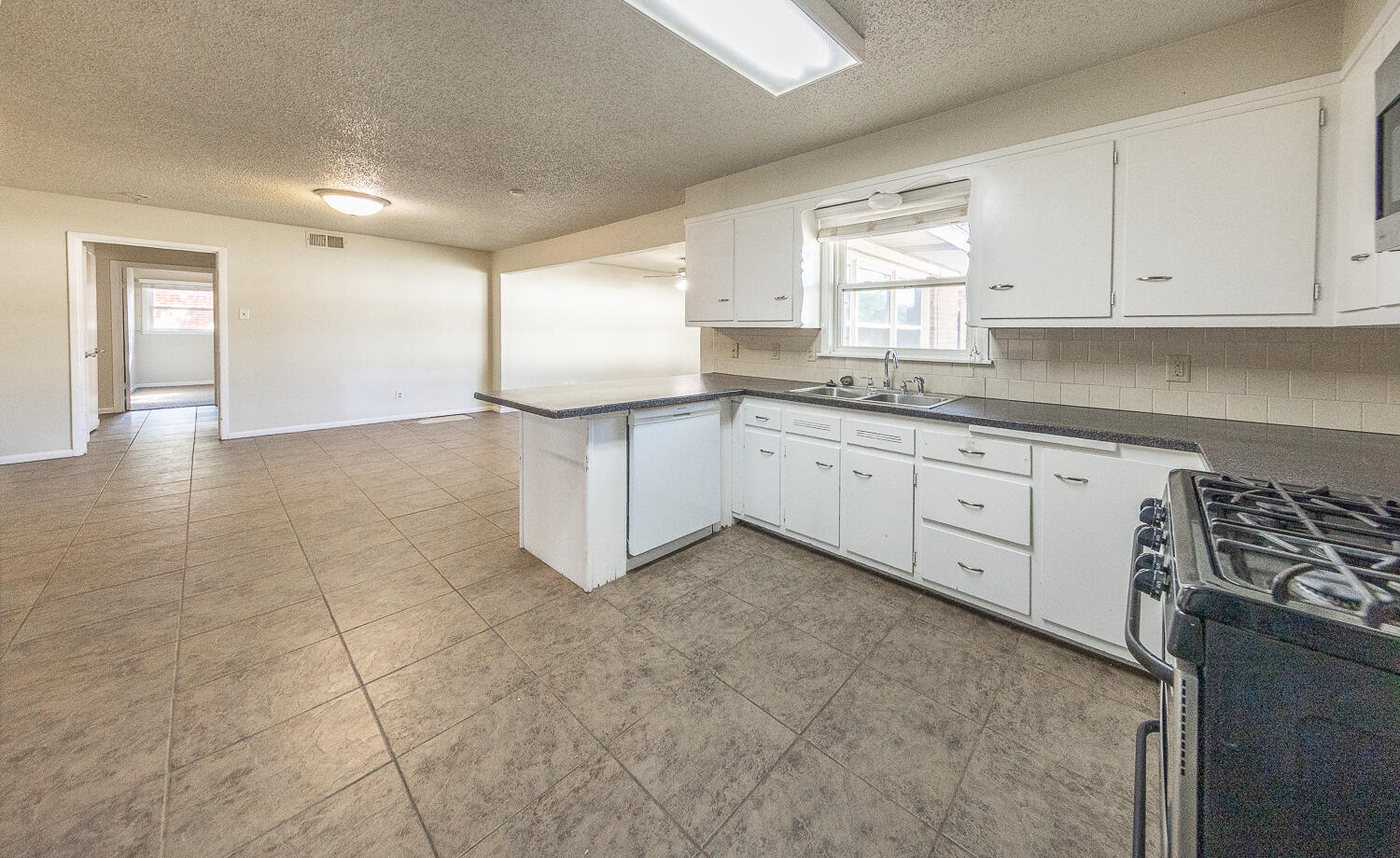 5017 46th Street Lubbock, TX 79414 - Photo 8 of 24 a kitchen with granite countertop white cabinets and white appliances