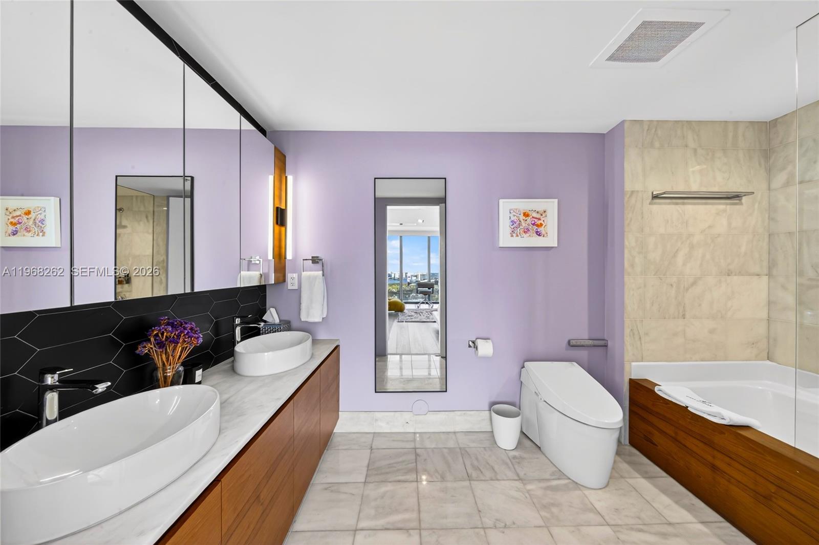 601 Northeast 36th Street, Unit 3407 Miami, FL 33137 - Photo 11 of 41 a bathroom with a granite countertop bathtub sink vanity mirror and toilet