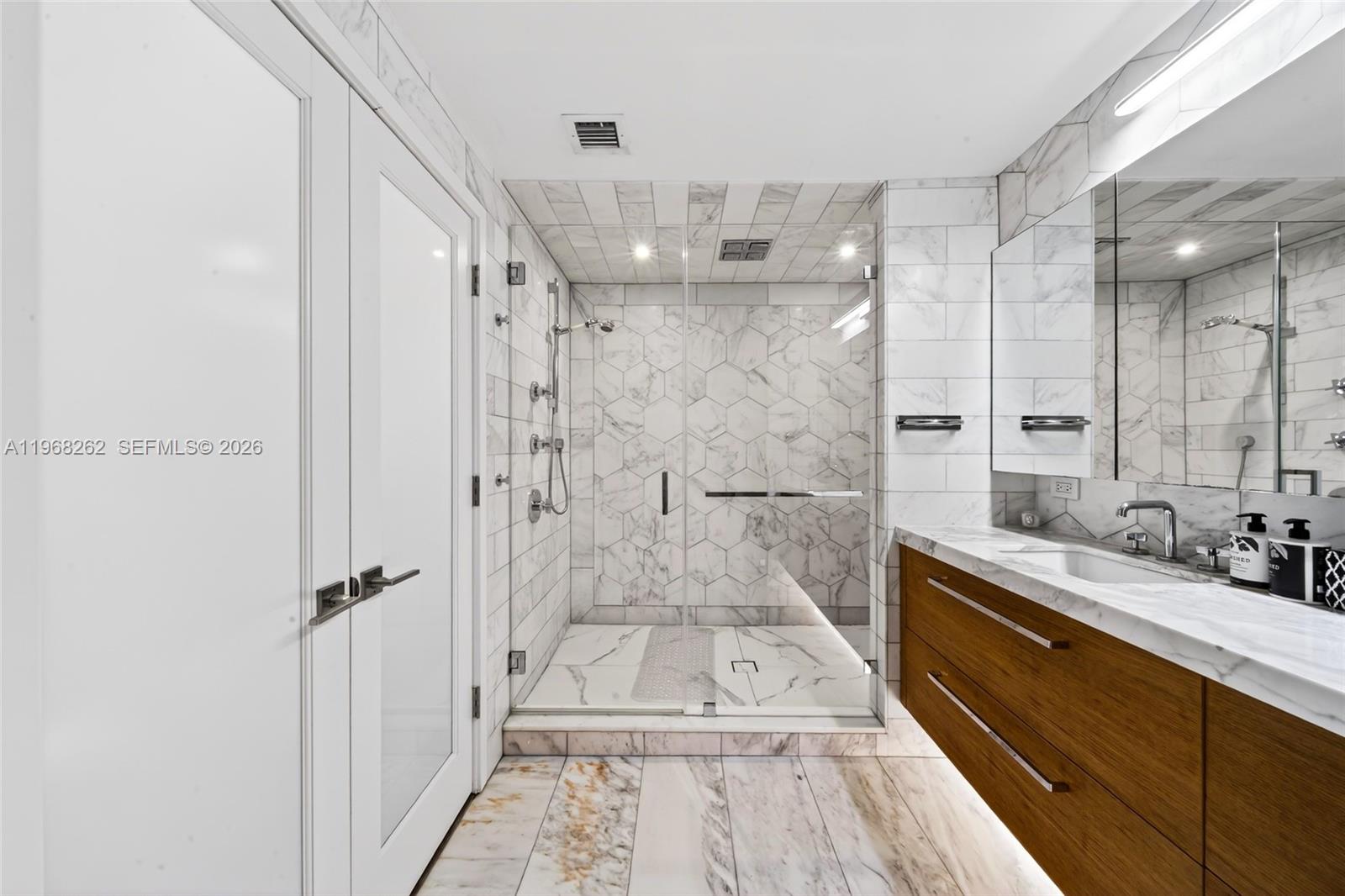 601 Northeast 36th Street, Unit 3407 Miami, FL 33137 - Photo 23 of 41 a bathroom with a sink a toilet a mirror and shower