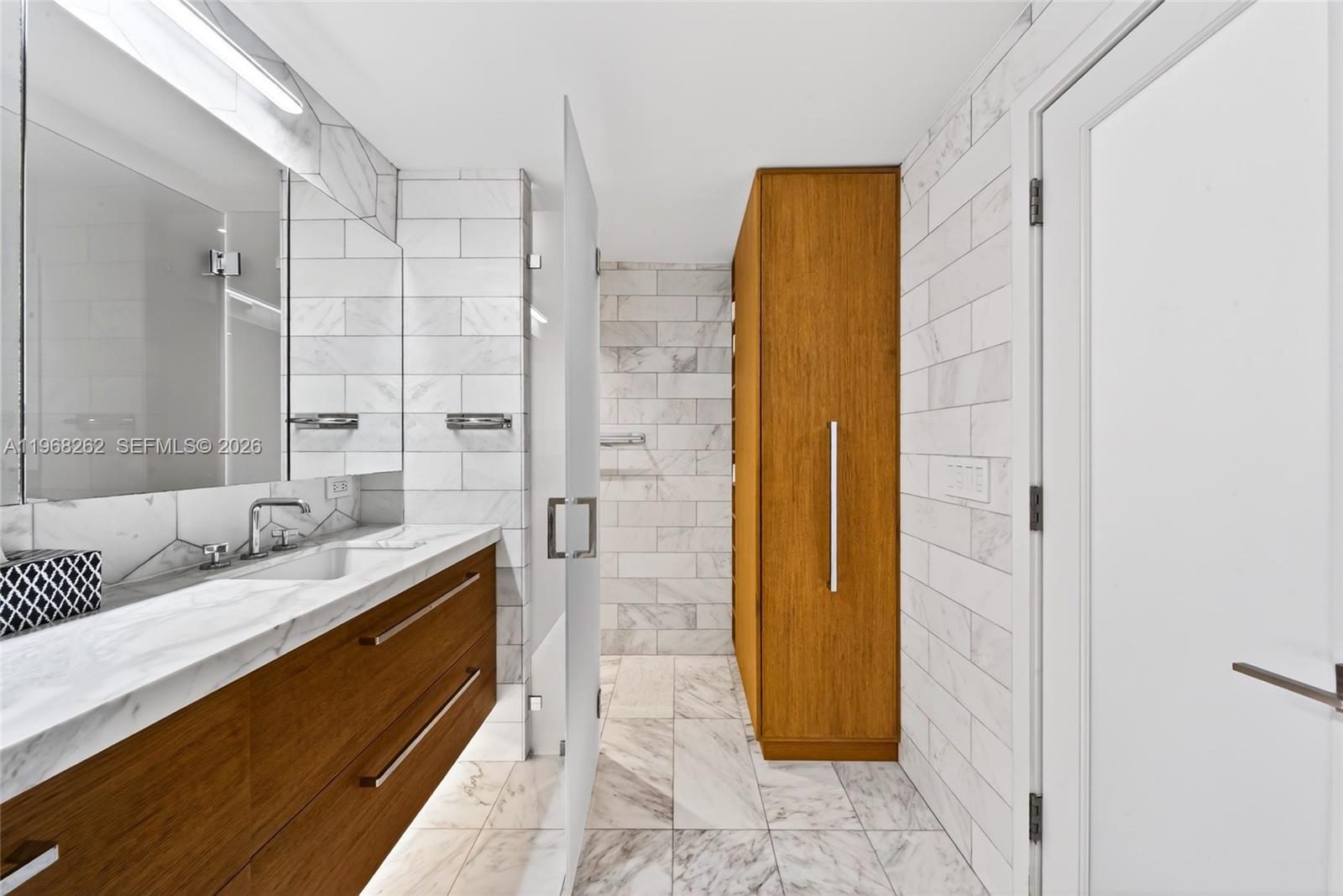 601 Northeast 36th Street, Unit 3407 Miami, FL 33137 - Photo 24 of 41 a bathroom with a granite countertop sink and a mirror
