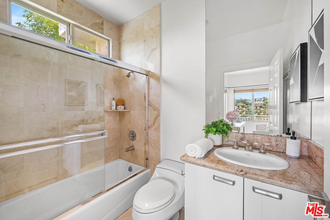 1991 Stradella Road Los Angeles, CA 90077 - Photo 22 of 26 a bathroom with a granite countertop sink toilet and shower