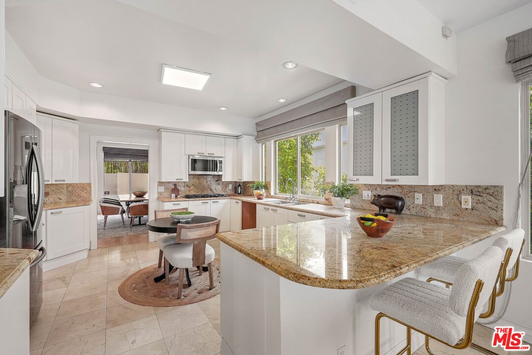 1991 Stradella Road Los Angeles, CA 90077 - Photo 10 of 26 a kitchen with granite countertop a sink and white cabinets