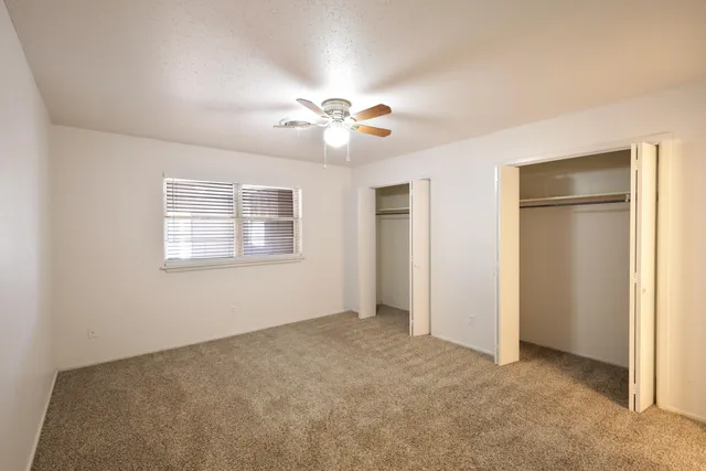 a view of an empty room with a ceiling fan