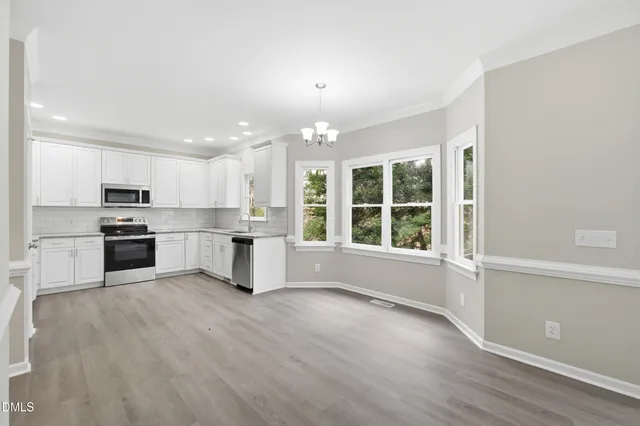 a view of an empty room with wooden floor and fence