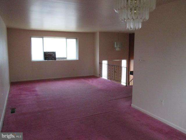 8800 Sigrid Road Randallstown, MD 21133 - Photo 3 of 16 en empty room with windows and chandelier fan