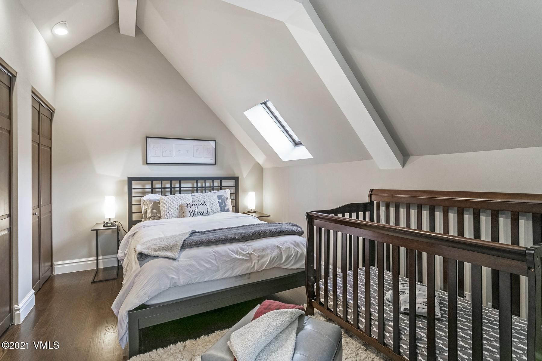 3000 Eaglebend Drive, Unit 1 Avon, CO 81620 - Photo 27 of 41 a bedroom with a bed and a chandelier