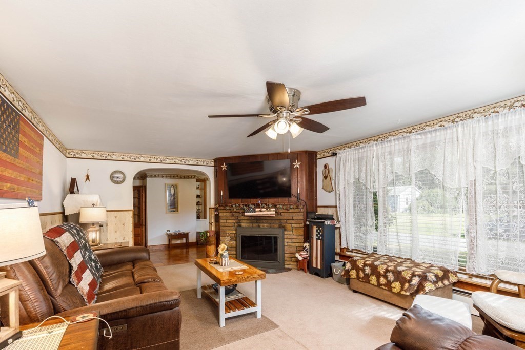 75 East Myrtle Street Orange, MA 01364 - Photo 5 of 28 a living room with furniture a flat screen tv and a fireplace