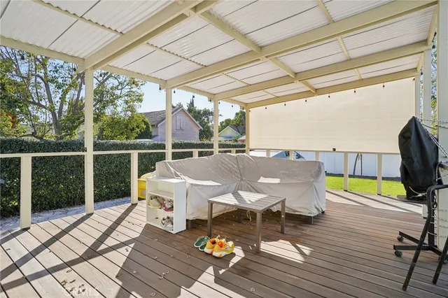 a balcony with wooden floor table and chairs