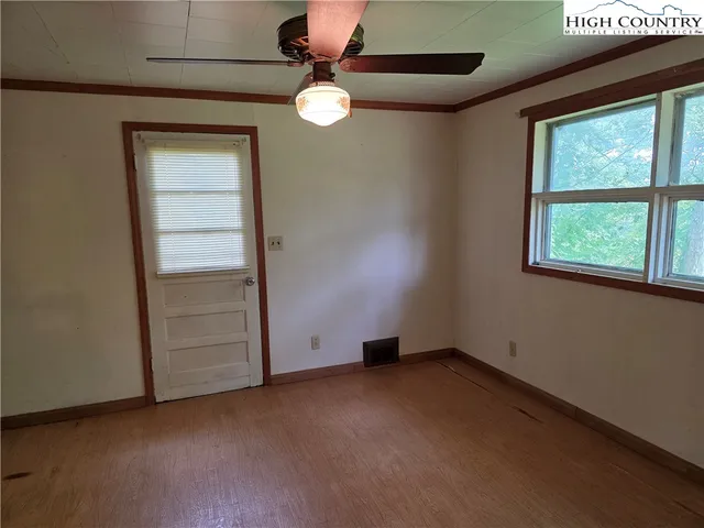 an empty room with windows and fan