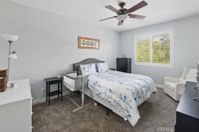 a bedroom with a bed and ceiling fan