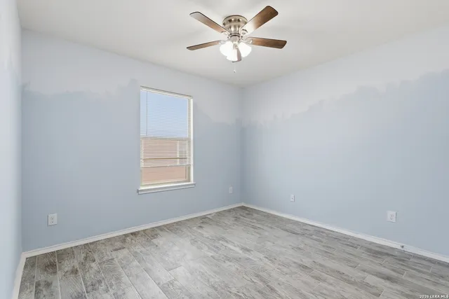an empty room with a window and a fan