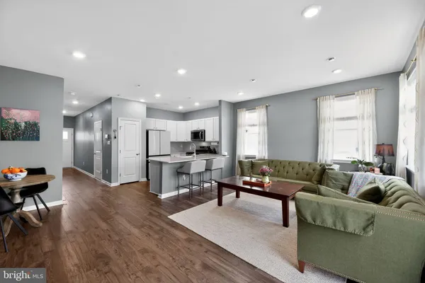 a living room with furniture and a dining table with kitchen view