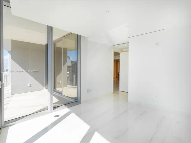 a view of a hallway with wooden floor and glass door
