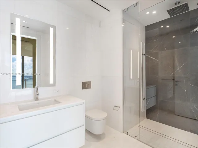 a bathroom with a granite countertop sink a toilet and shower