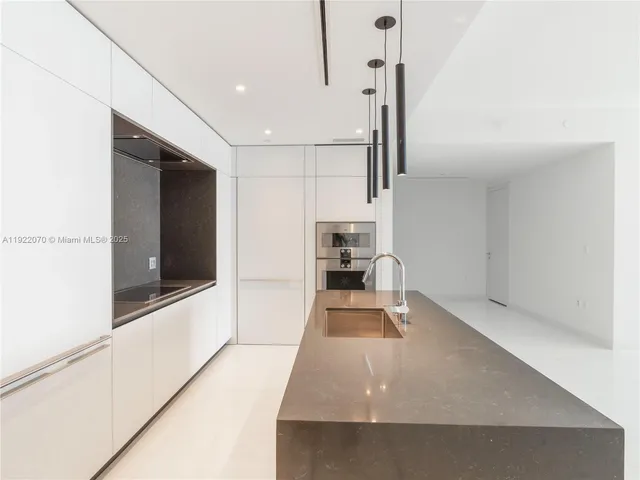 a view of a kitchen with a sink and dishwasher with a living room