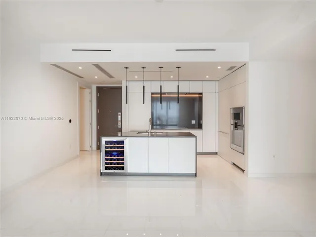 a view of kitchen with cabinets and refrigerator