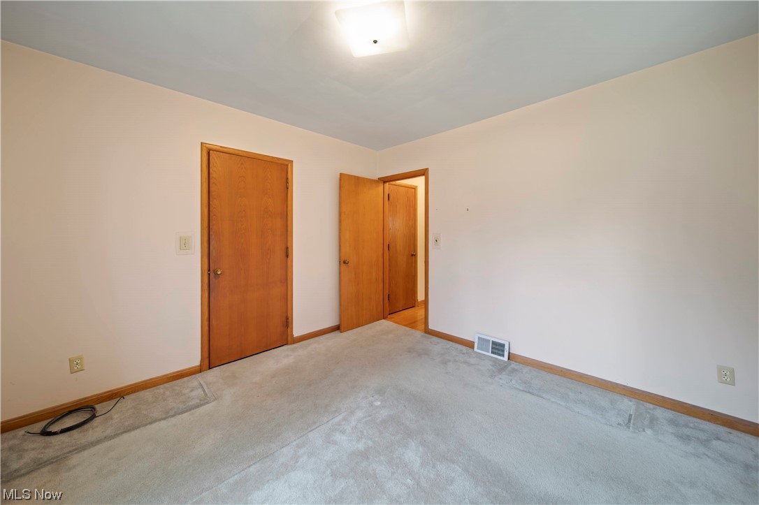 6835 Lake Road East Madison, OH 44057 - Photo 10 of 25 Main floor bedroom 11 x 11 with carpeting and hardwood flooring underneath.