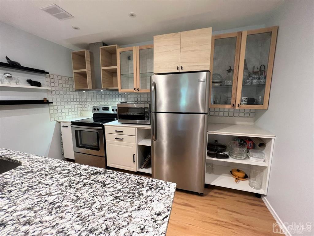 a kitchen with a refrigerator and a stove top oven