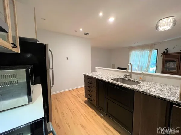 a kitchen with stainless steel appliances granite countertop a sink and a stove