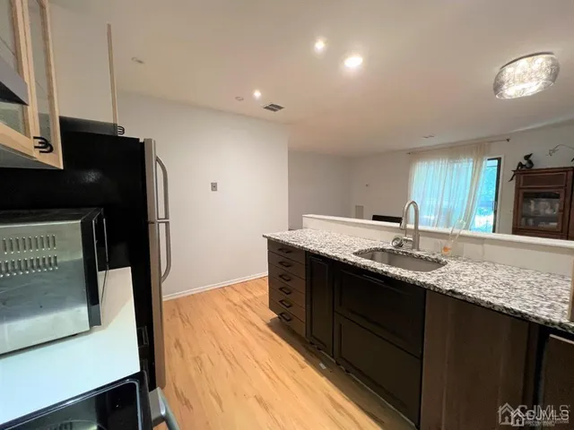 a kitchen with stainless steel appliances granite countertop a sink and a stove