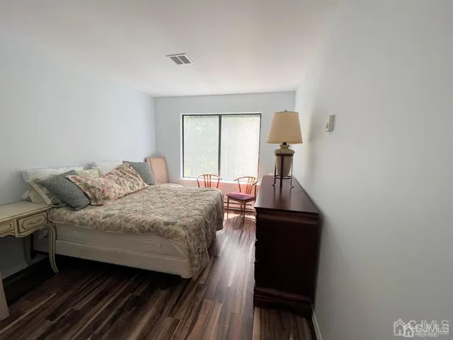 a bedroom with a bed window and dresser