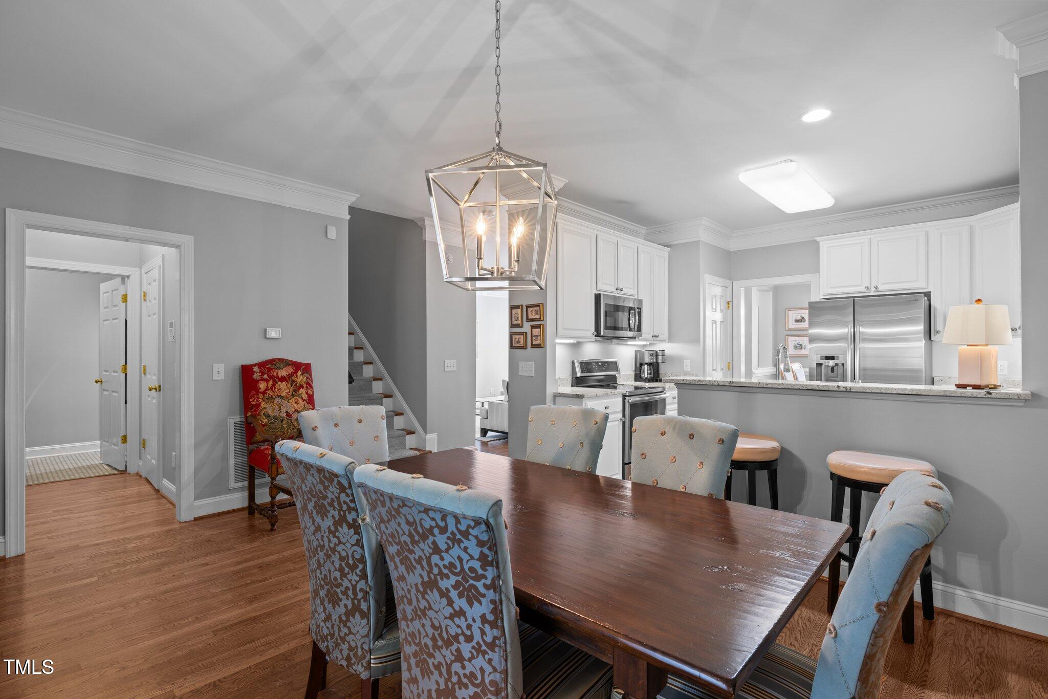 3902 Stags Leap Circle Raleigh, NC 27612 - Photo 17 of 53 a view of a dining room with furniture wooden floor and a chandelier