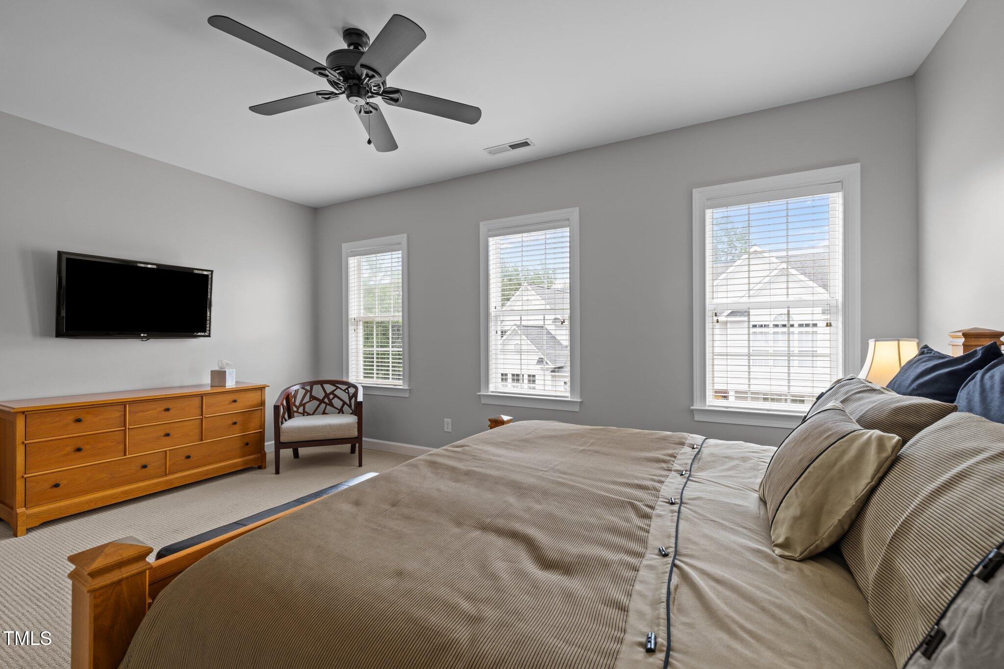 3902 Stags Leap Circle Raleigh, NC 27612 - Photo 22 of 53 a bedroom with a bed and a flat screen tv