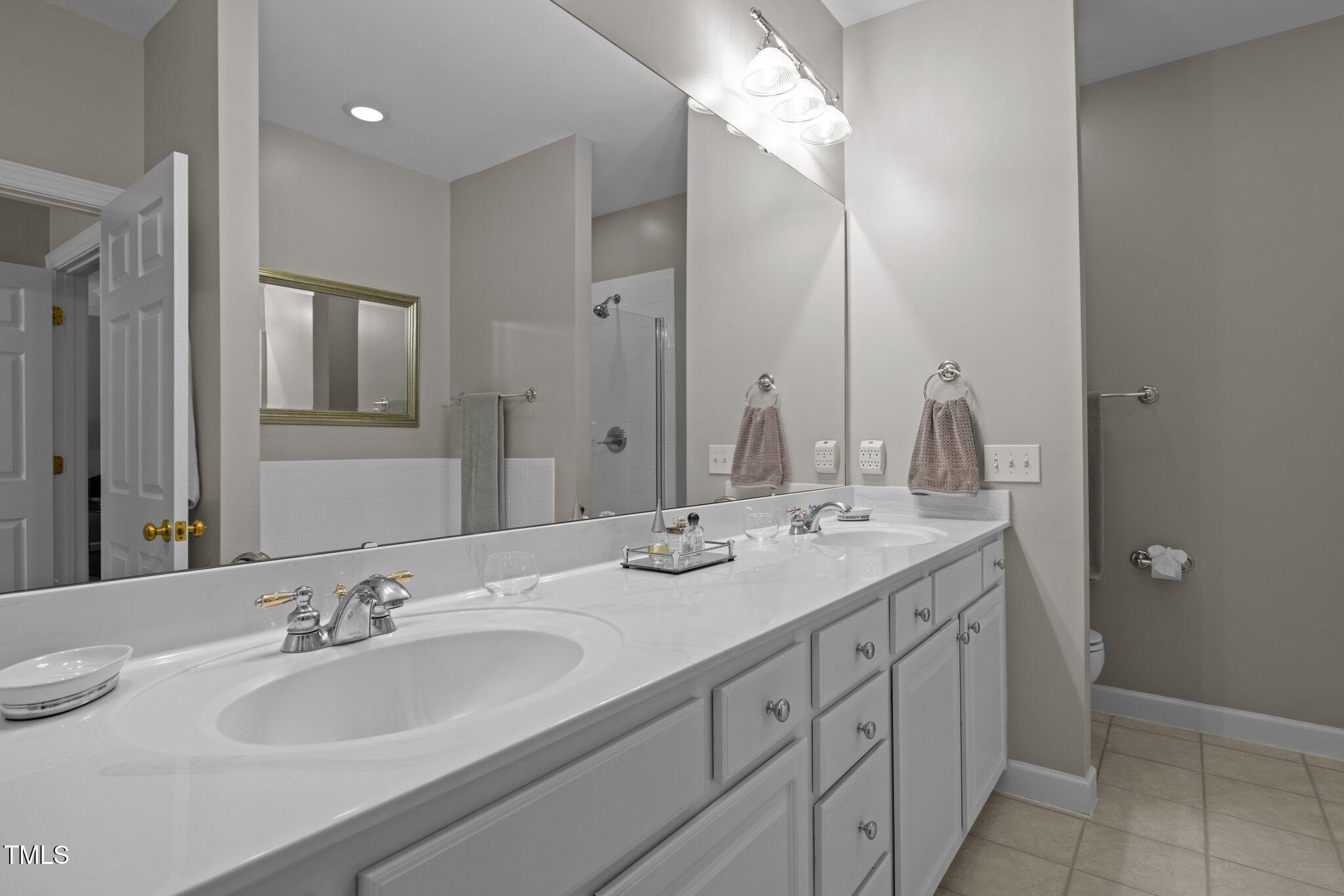 3902 Stags Leap Circle Raleigh, NC 27612 - Photo 23 of 53 a bathroom with a double vanity sink and a mirror