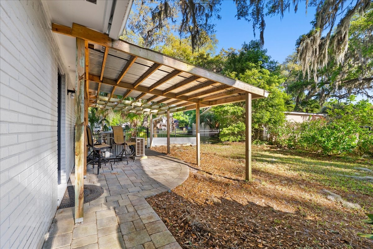 85316 Avant Road Yulee, FL 32097 - Photo 43 of 62 a view of a patio with table and chairs under an umbrella with a small yard