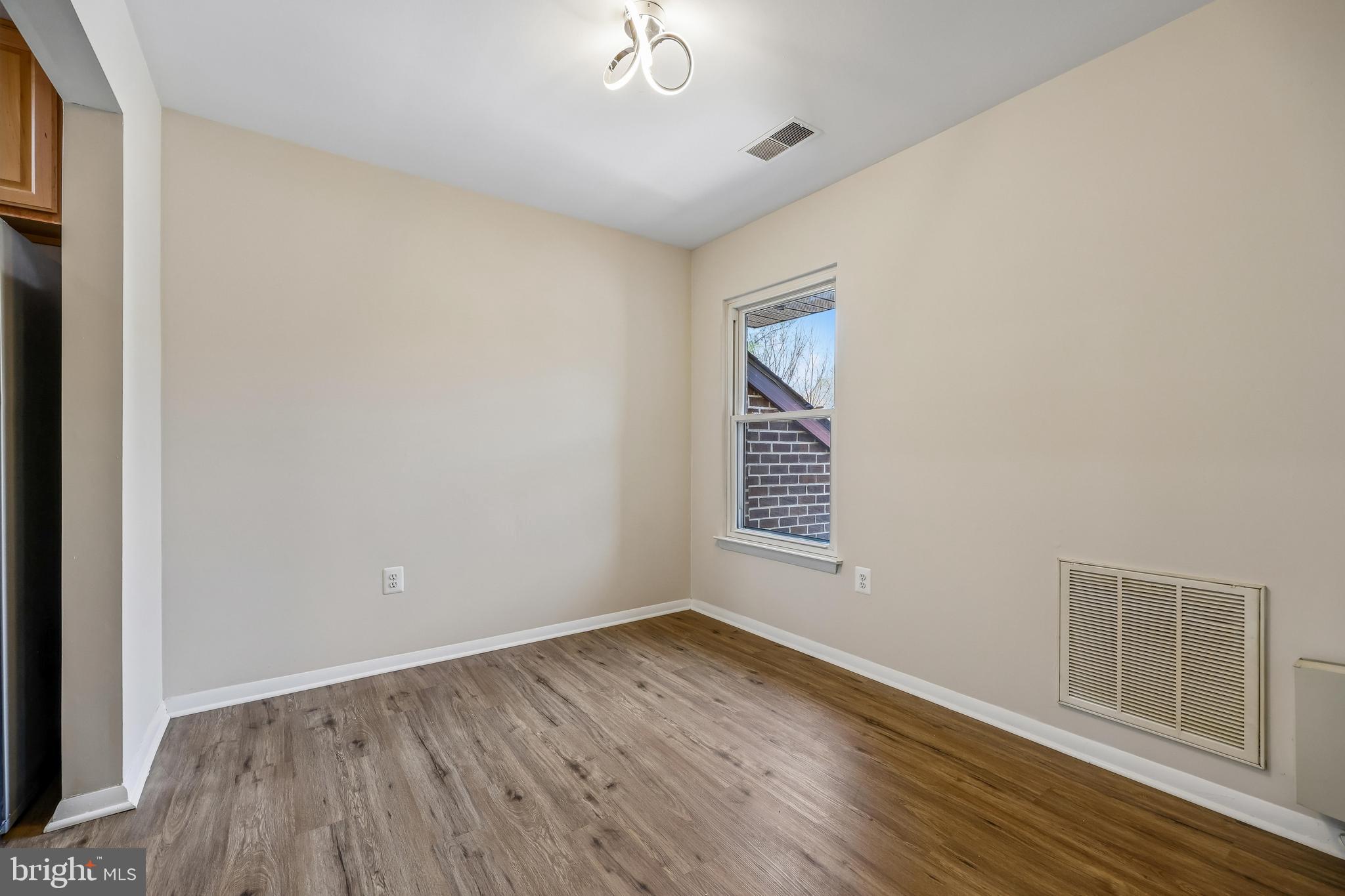 7804 Guildberry Court, Unit 301 Gaithersburg, MD 20879 - Photo 11 of 33 an empty room with wooden floor and windows