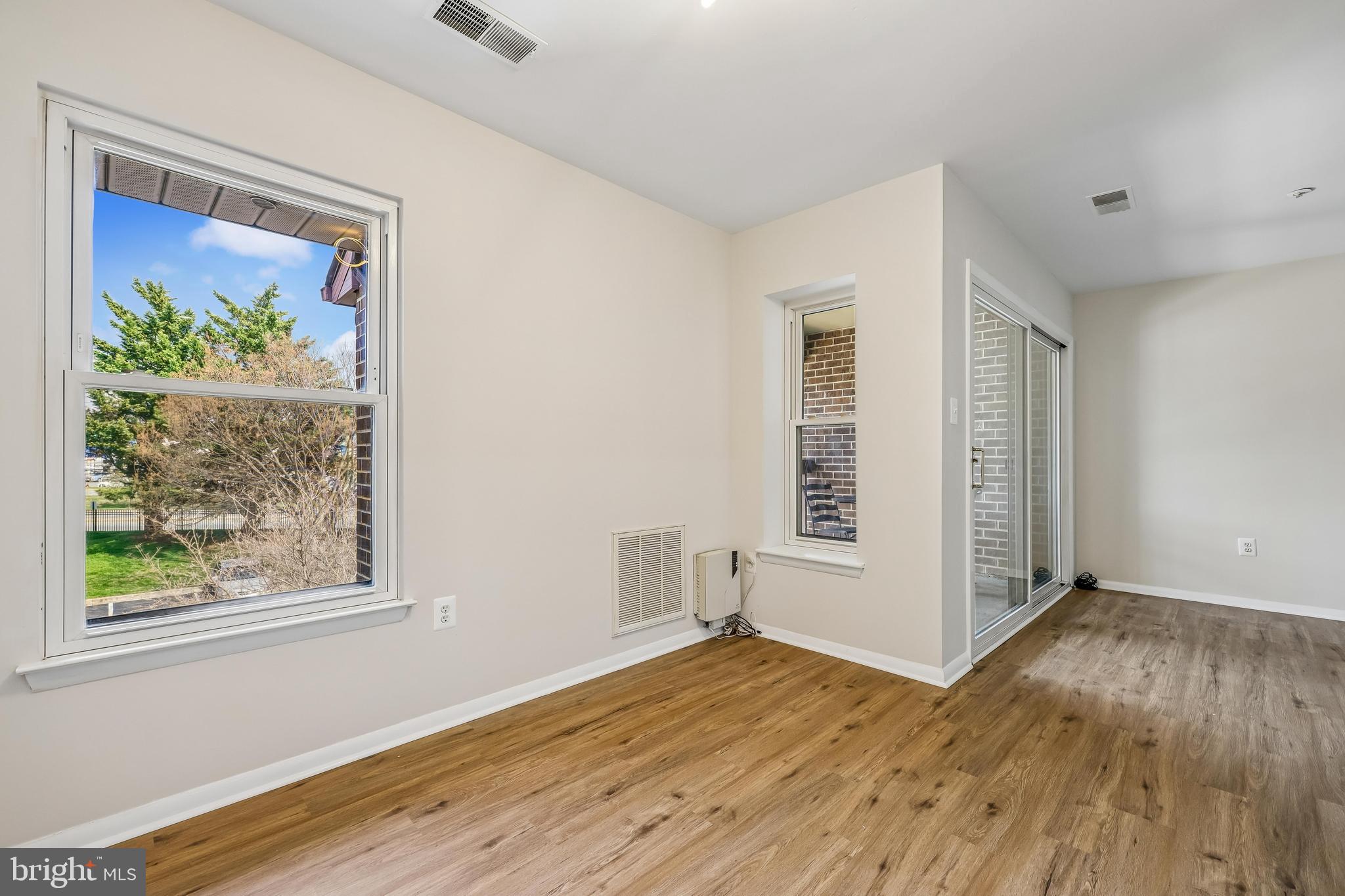 7804 Guildberry Court, Unit 301 Gaithersburg, MD 20879 - Photo 12 of 33 an empty room with wooden floor and windows