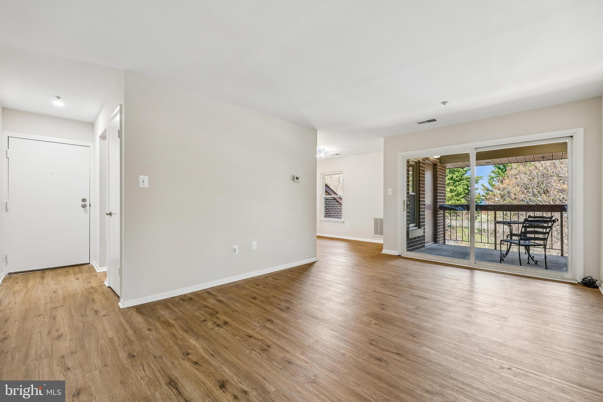 7804 Guildberry Court, Unit 301 Gaithersburg, MD 20879 - Photo 13 of 33 a view of an empty room with wooden floor and a window