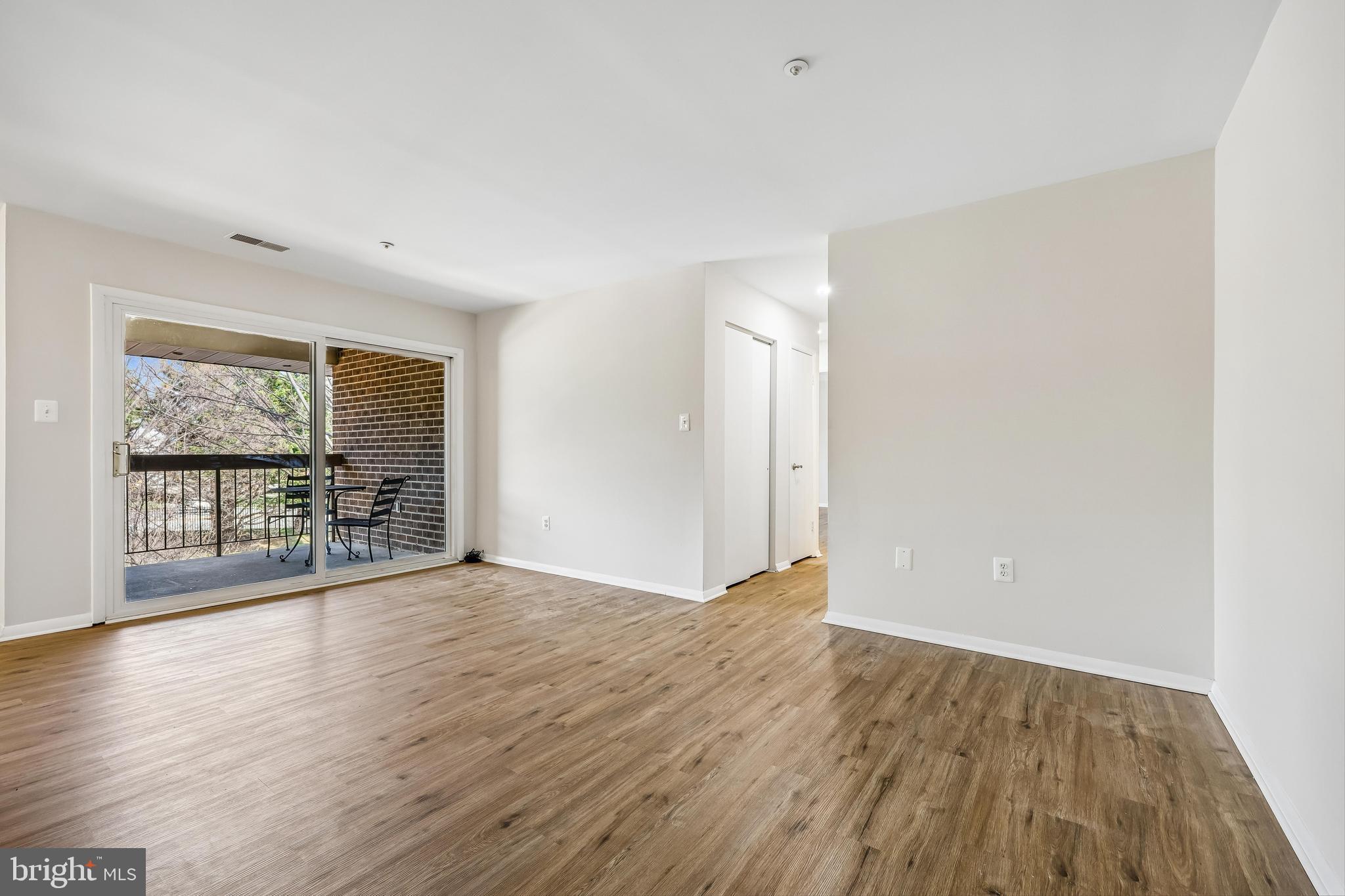 7804 Guildberry Court, Unit 301 Gaithersburg, MD 20879 - Photo 18 of 33 a view of an empty room with wooden floor and a window