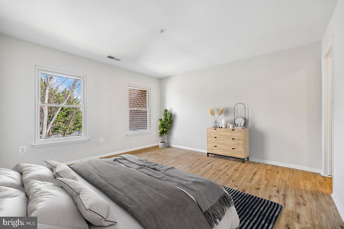 7804 Guildberry Court, Unit 301 Gaithersburg, MD 20879 - Photo 27 of 33 a bedroom with a bed and wooden floor