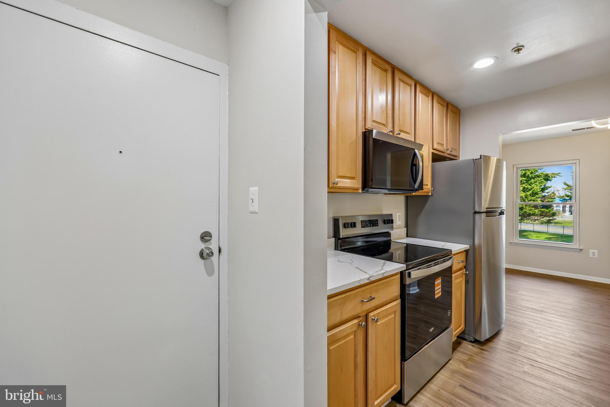 7804 Guildberry Court, Unit 301 Gaithersburg, MD 20879 - Photo 4 of 33 a kitchen with stainless steel appliances granite countertop a refrigerator a stove a sink and a microwave
