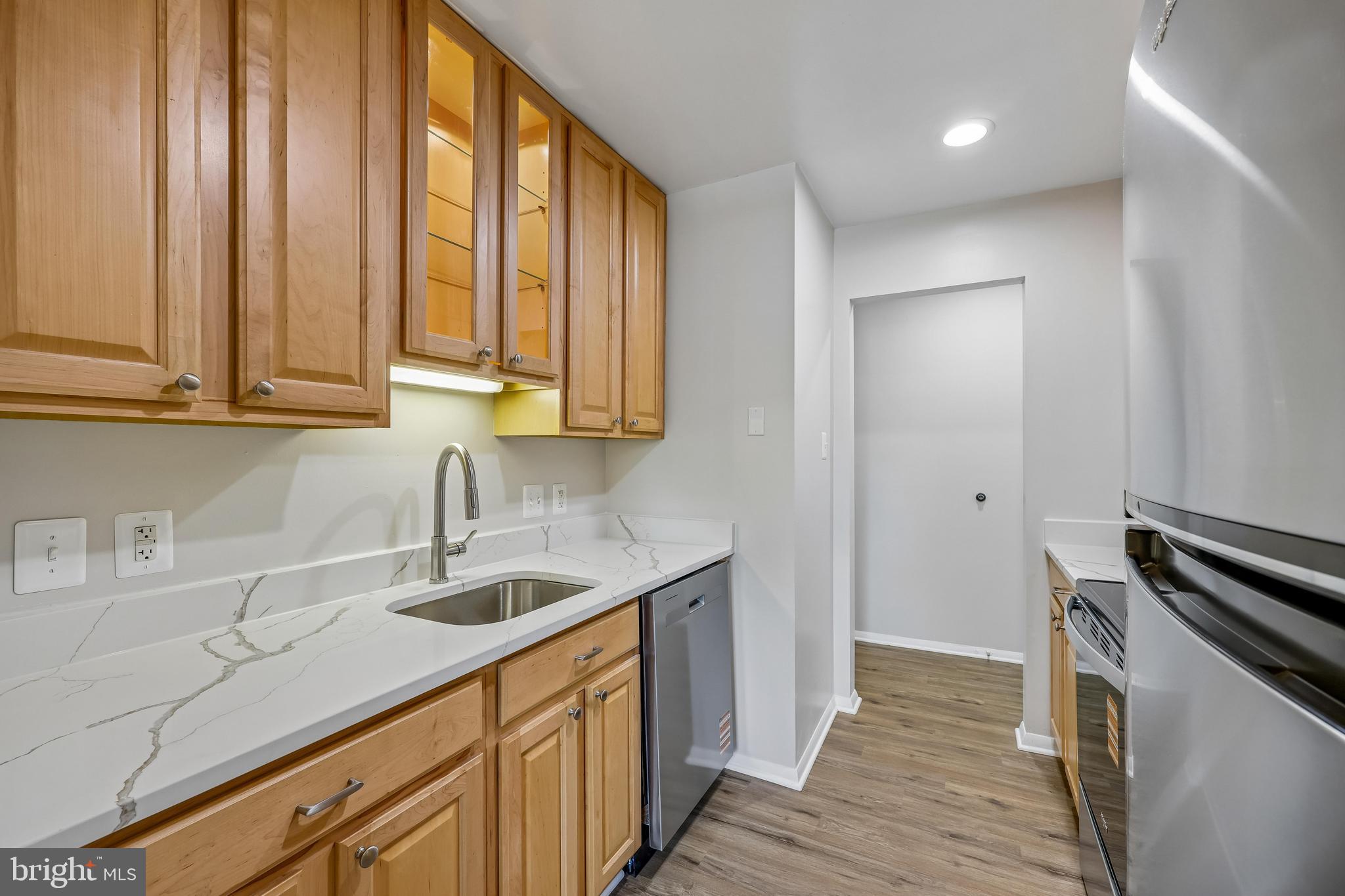 7804 Guildberry Court, Unit 301 Gaithersburg, MD 20879 - Photo 6 of 33 a kitchen with stainless steel appliances granite countertop a sink a stove and a wooden floors
