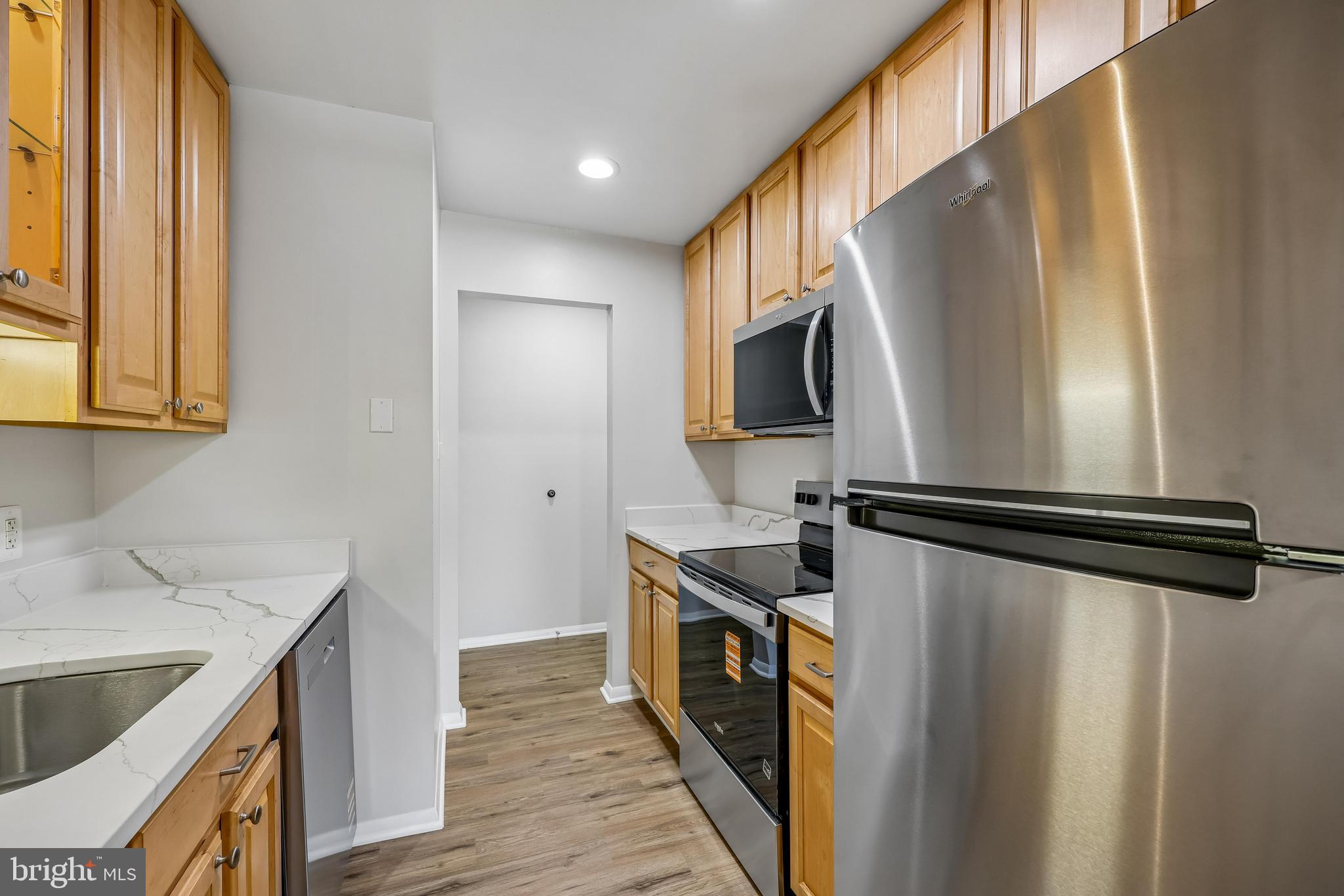 7804 Guildberry Court, Unit 301 Gaithersburg, MD 20879 - Photo 7 of 33 a kitchen with a refrigerator a sink and cabinets